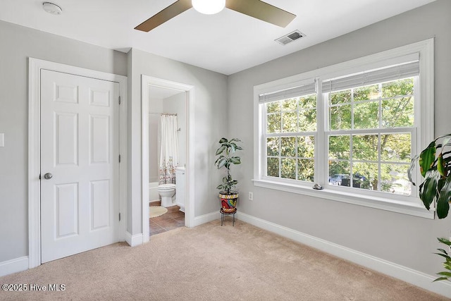 bedroom featuring multiple windows, visible vents, baseboards, and light carpet