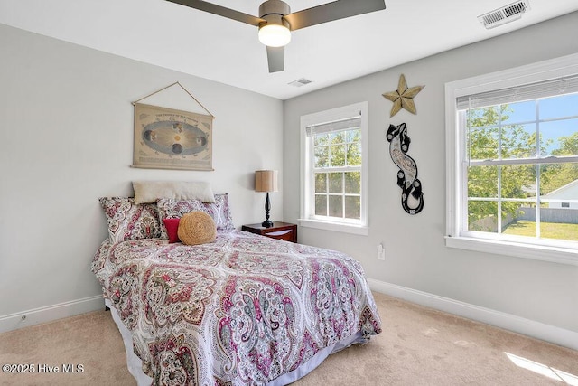 bedroom featuring baseboards, multiple windows, and carpet