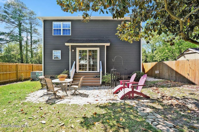 rear view of house featuring a fenced backyard, entry steps, a patio, and cooling unit