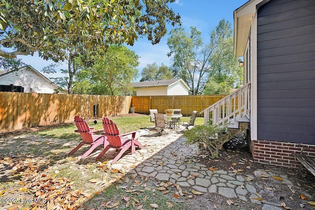 view of yard with a fenced backyard, a patio, and outdoor dining area