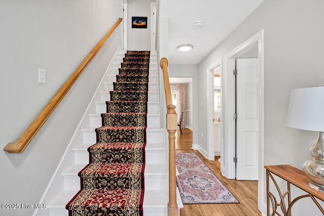 stairs with baseboards and wood finished floors
