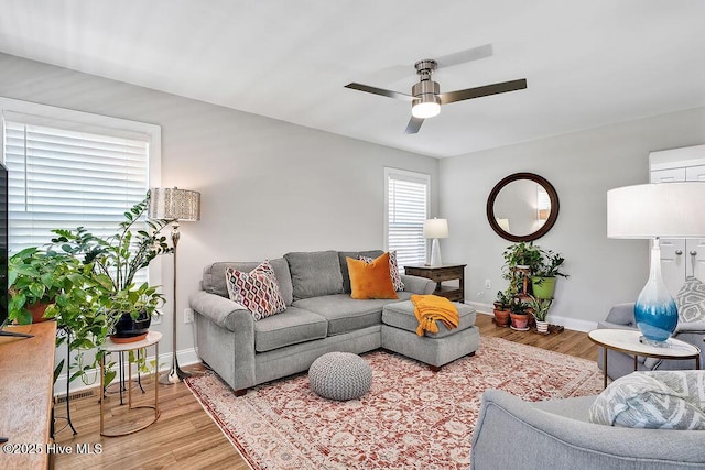 living room with baseboards, a ceiling fan, and wood finished floors