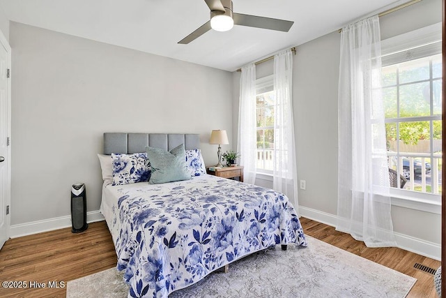 bedroom featuring multiple windows and wood finished floors