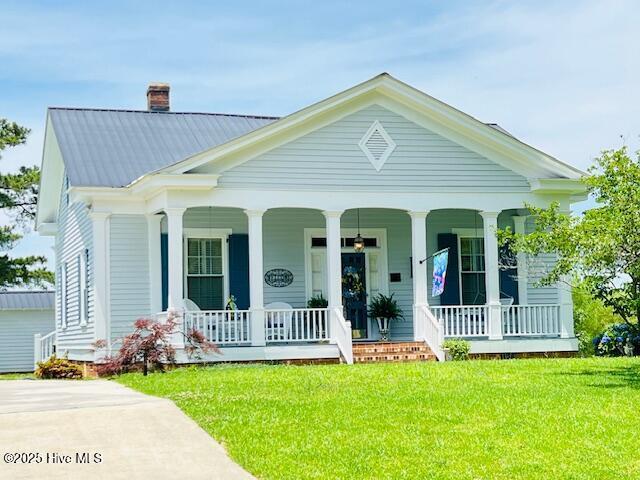 45 Hb Lewis Rd, Clinton, NC 28328 - view of front of house with covered porch, a chimney, a front lawn, and metal roof