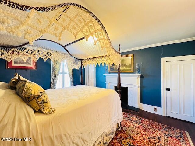 45 Hb Lewis Rd, Clinton, NC 28328 - bedroom featuring wood finished floors, baseboards, crown molding, and a fireplace with raised hearth