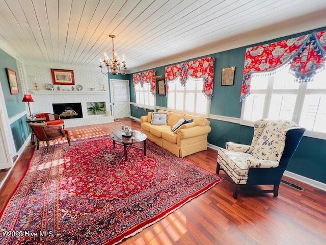 45 Hb Lewis Rd, Clinton, NC 28328 - living room featuring plenty of natural light, a chandelier, wood finished floors, wooden ceiling, and a brick fireplace