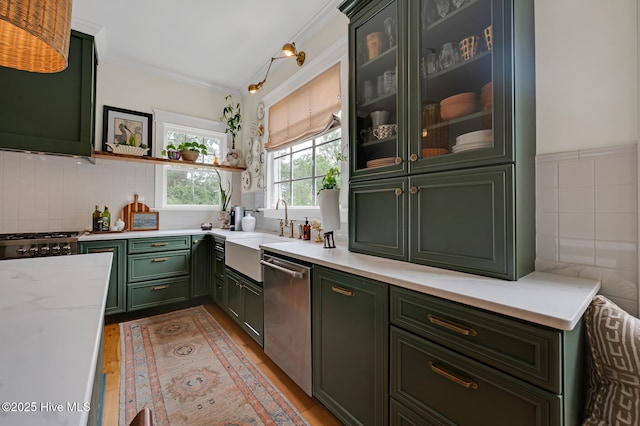 kitchen with stainless steel dishwasher, light wood finished floors, a sink, open shelves, and green cabinetry
