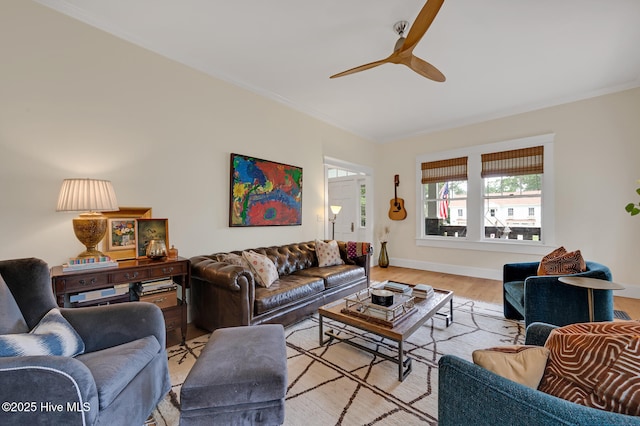 living room featuring baseboards, crown molding, ceiling fan, and light wood-style floors
