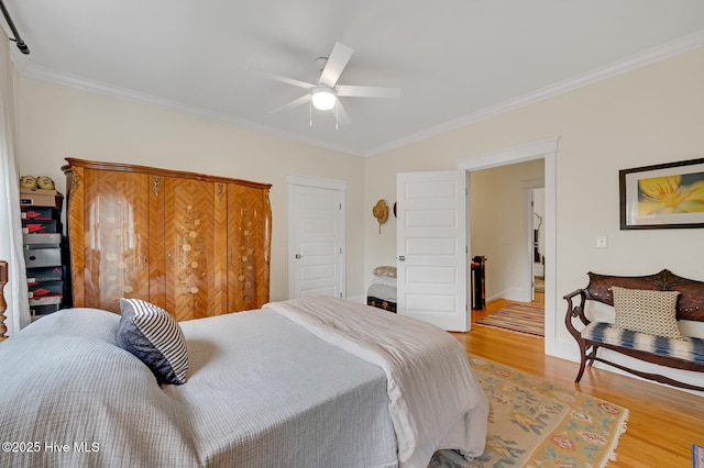 bedroom featuring crown molding, light wood-style floors, and a ceiling fan