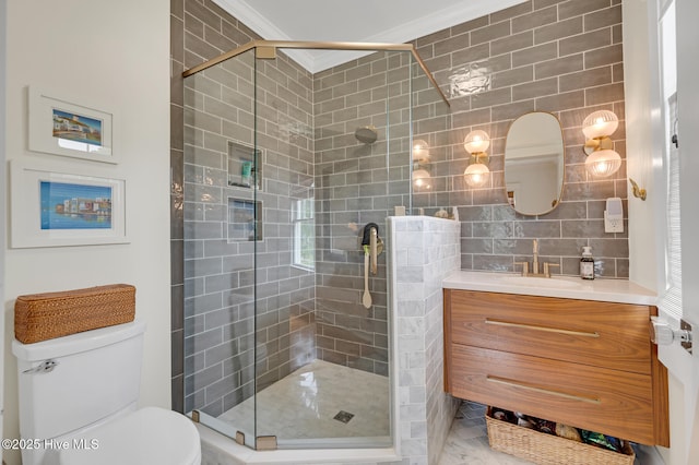 bathroom with a stall shower, vanity, ornamental molding, and toilet