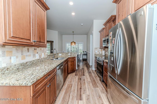 kitchen with stainless steel appliances, light wood-type flooring, a sink, decorative backsplash, and recessed lighting