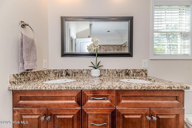 full bath with double vanity and toilet