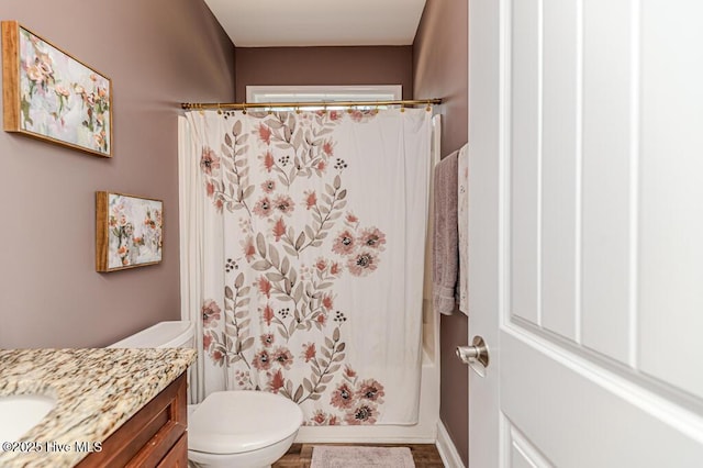 bathroom with vanity, toilet, wood finished floors, and shower / bathtub combination with curtain