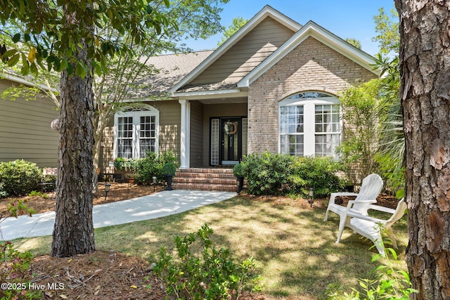 4145 Brighton Ln, Southport, NC 28461 - view of front of property featuring a front lawn, brick siding, and roof with shingles