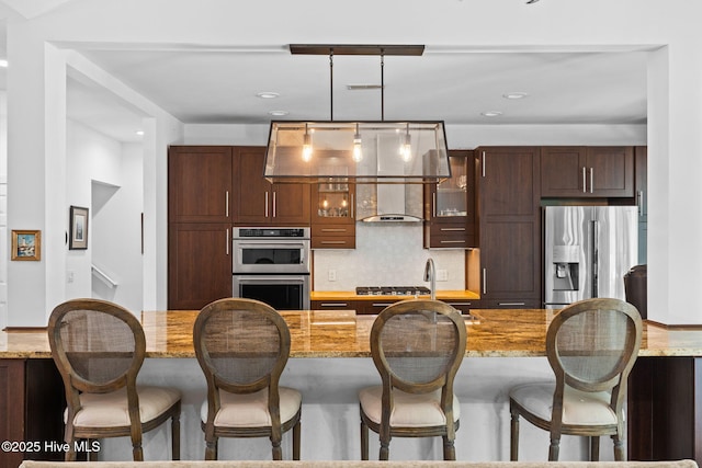4145 Brighton Ln, Southport, NC 28461 - kitchen featuring tasteful backsplash, a breakfast bar area, pendant lighting, glass insert cabinets, and appliances with stainless steel finishes