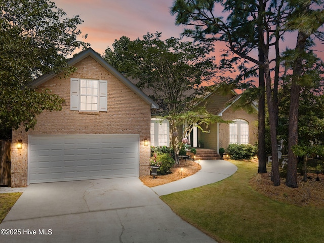 4145 Brighton Ln, Southport, NC 28461 - traditional home with concrete driveway, a garage, brick siding, and a front yard