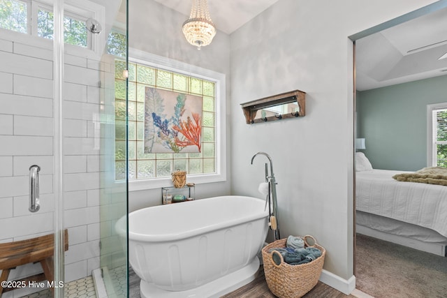 4145 Brighton Ln, Southport, NC 28461 - ensuite bathroom featuring baseboards, an inviting chandelier, a shower stall, connected bathroom, and a freestanding bath