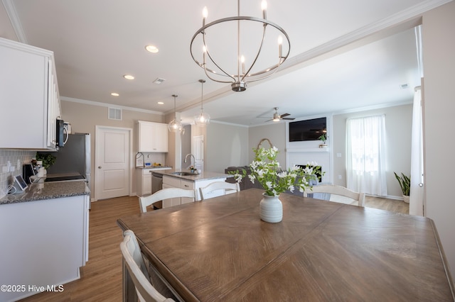 4524 Sweet Williams Ln NW, Wilson, NC 27896 - dining room with ceiling fan with notable chandelier, visible vents, light wood-style floors, ornamental molding, and recessed lighting
