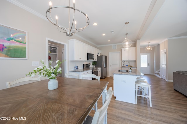 4524 Sweet Williams Ln NW, Wilson, NC 27896 - dining space featuring light wood finished floors, crown molding, visible vents, a chandelier, and recessed lighting