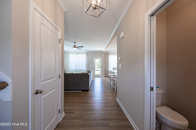 4524 Sweet Williams Ln NW, Wilson, NC 27896 - hall featuring baseboards, ornamental molding, dark wood finished floors, and an inviting chandelier