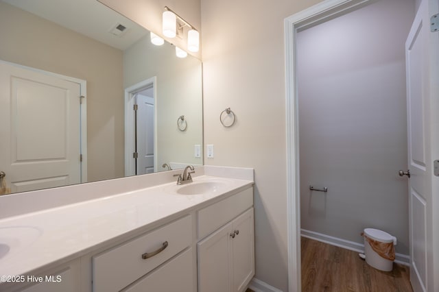 4524 Sweet Williams Ln NW, Wilson, NC 27896 - bathroom featuring baseboards, visible vents, a sink, double vanity, and wood finished floors