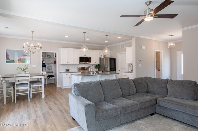 4524 Sweet Williams Ln NW, Wilson, NC 27896 - living area featuring recessed lighting, light wood finished floors, visible vents, ceiling fan with notable chandelier, and crown molding
