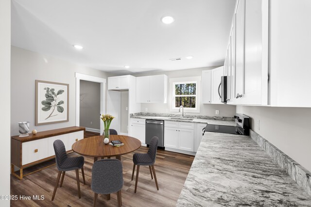 1191 Pierce Rd, Southport, NC 28461 - kitchen featuring a sink, stainless steel appliances, wood finished floors, visible vents, and white cabinetry