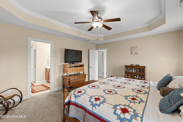 bedroom featuring crown molding, light carpet, a raised ceiling, baseboards, and ensuite bathroom