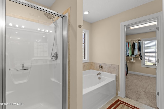 full bath with a stall shower, a bath, and tile patterned floors