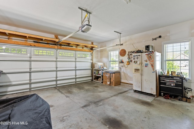 garage featuring white fridge with ice dispenser and a garage door opener