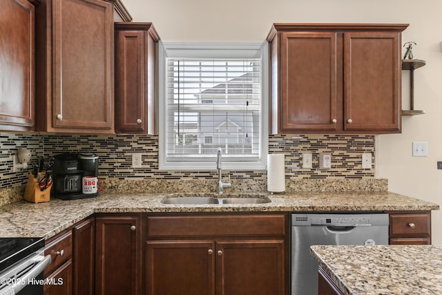 kitchen featuring a sink, stainless steel appliances, tasteful backsplash, and light stone countertops