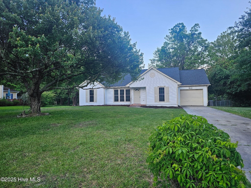 ranch-style house featuring an attached garage, driveway, and a front lawn
