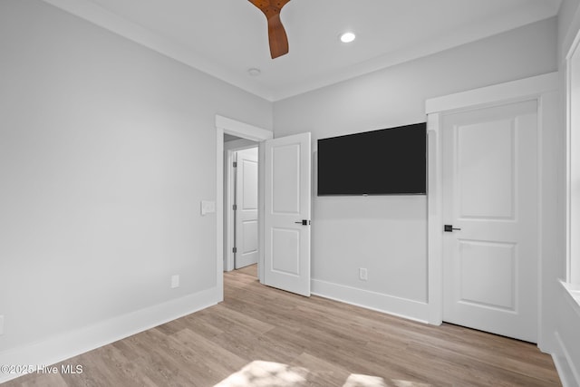 unfurnished bedroom featuring baseboards, a ceiling fan, and light wood-style floors