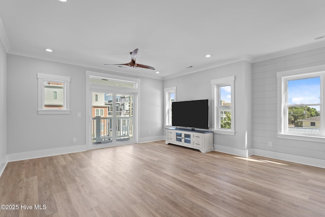 unfurnished living room featuring ornamental molding, a wealth of natural light, and a ceiling fan