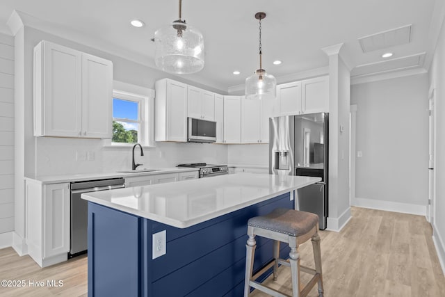 kitchen featuring a sink, a kitchen breakfast bar, white cabinets, visible vents, and appliances with stainless steel finishes