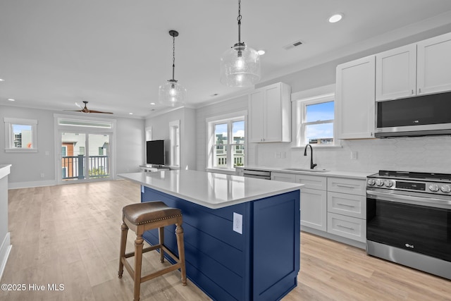 kitchen featuring a sink, stainless steel appliances, open floor plan, visible vents, and a kitchen island