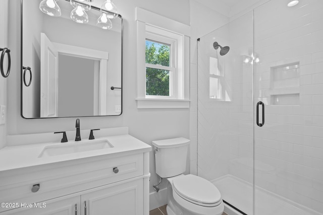 full bathroom featuring a stall shower, vanity, and toilet