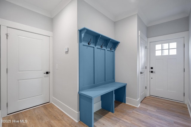 mudroom with ornamental molding, light wood-style flooring, and baseboards
