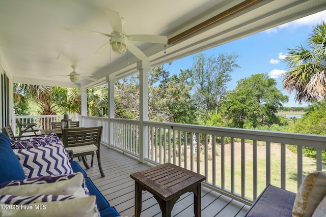 deck featuring ceiling fan and a water view