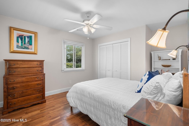 bedroom featuring baseboards, wood finished floors, a closet, and a ceiling fan