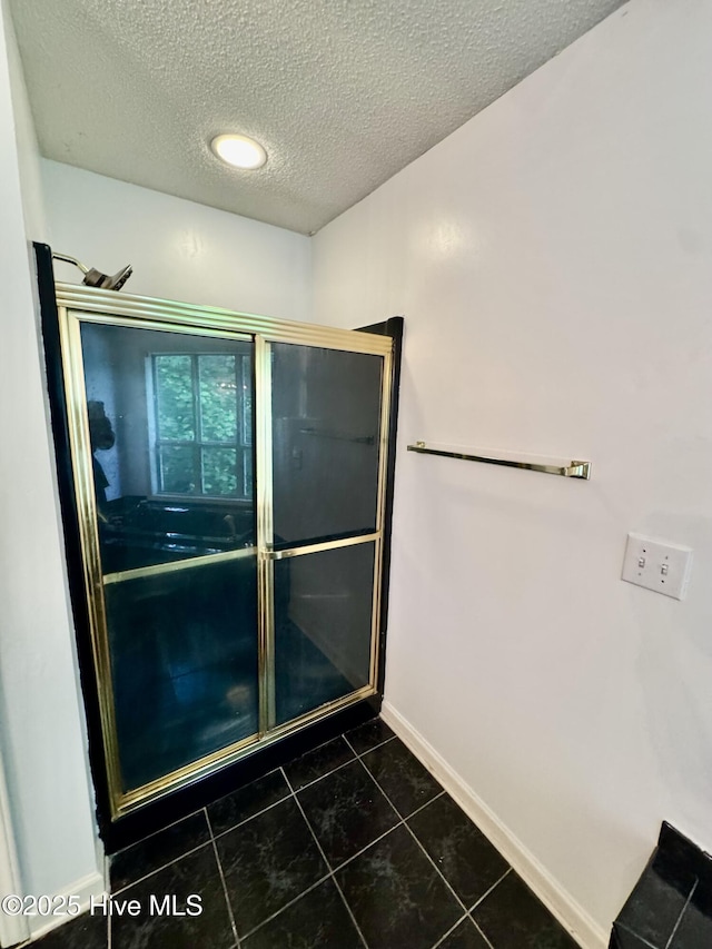 607 Spring Forest Rd Unit G, Greenville, NC 27834 - bathroom featuring a textured ceiling, baseboards, tile patterned flooring, and a shower stall