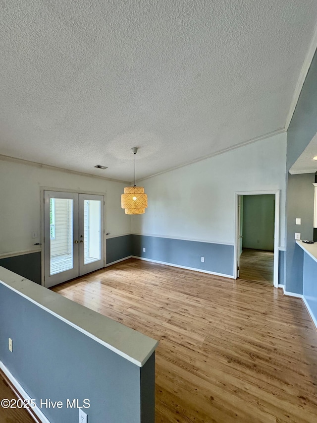607 Spring Forest Rd Unit G, Greenville, NC 27834 - unfurnished dining area featuring a textured ceiling, baseboards, french doors, and wood finished floors