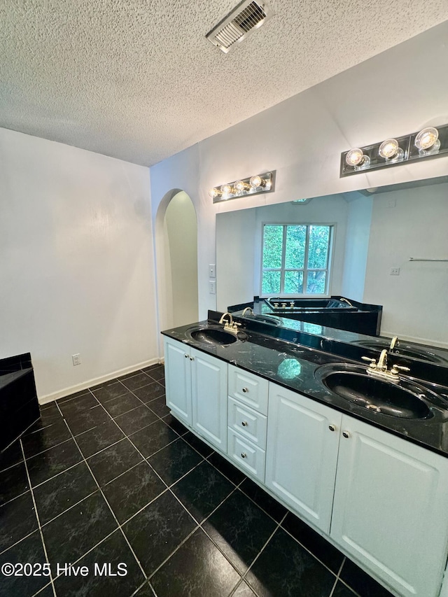 607 Spring Forest Rd Unit G, Greenville, NC 27834 - bathroom with a sink, double vanity, a textured ceiling, and tile patterned flooring