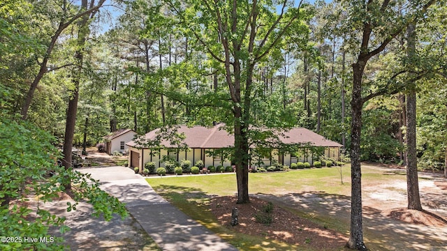 view of front facade featuring driveway and a front yard