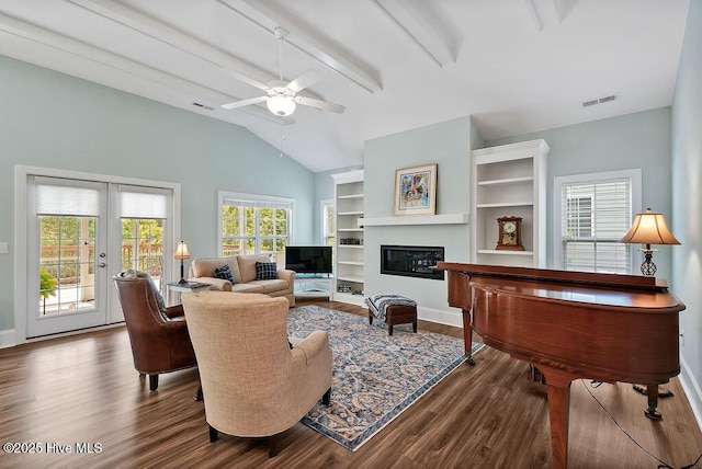 living area with dark wood-type flooring, ceiling fan, baseboards, french doors, and a glass covered fireplace