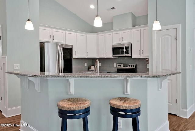 kitchen with stainless steel appliances, dark wood-type flooring, baseboards, decorative backsplash, and white cabinetry