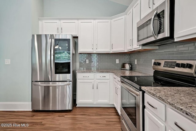 kitchen featuring stainless steel appliances, white cabinets, backsplash, and wood finished floors