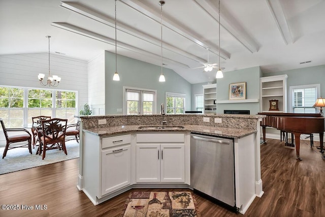 kitchen featuring dishwasher, a sink, a fireplace, a ceiling fan, and open floor plan