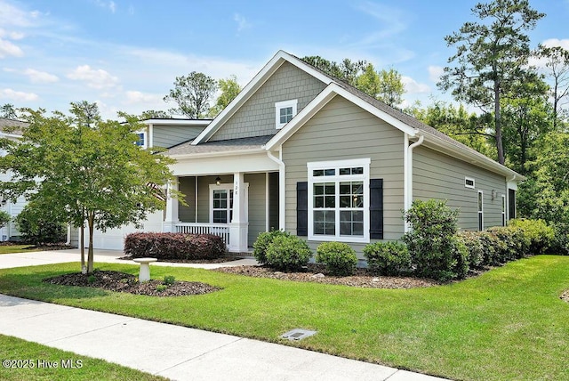 view of front of property featuring covered porch, a front lawn, and driveway