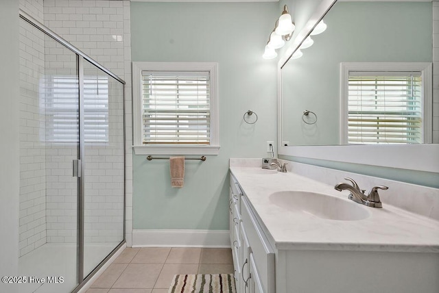 bathroom featuring tile patterned floors, a shower stall, baseboards, and double vanity
